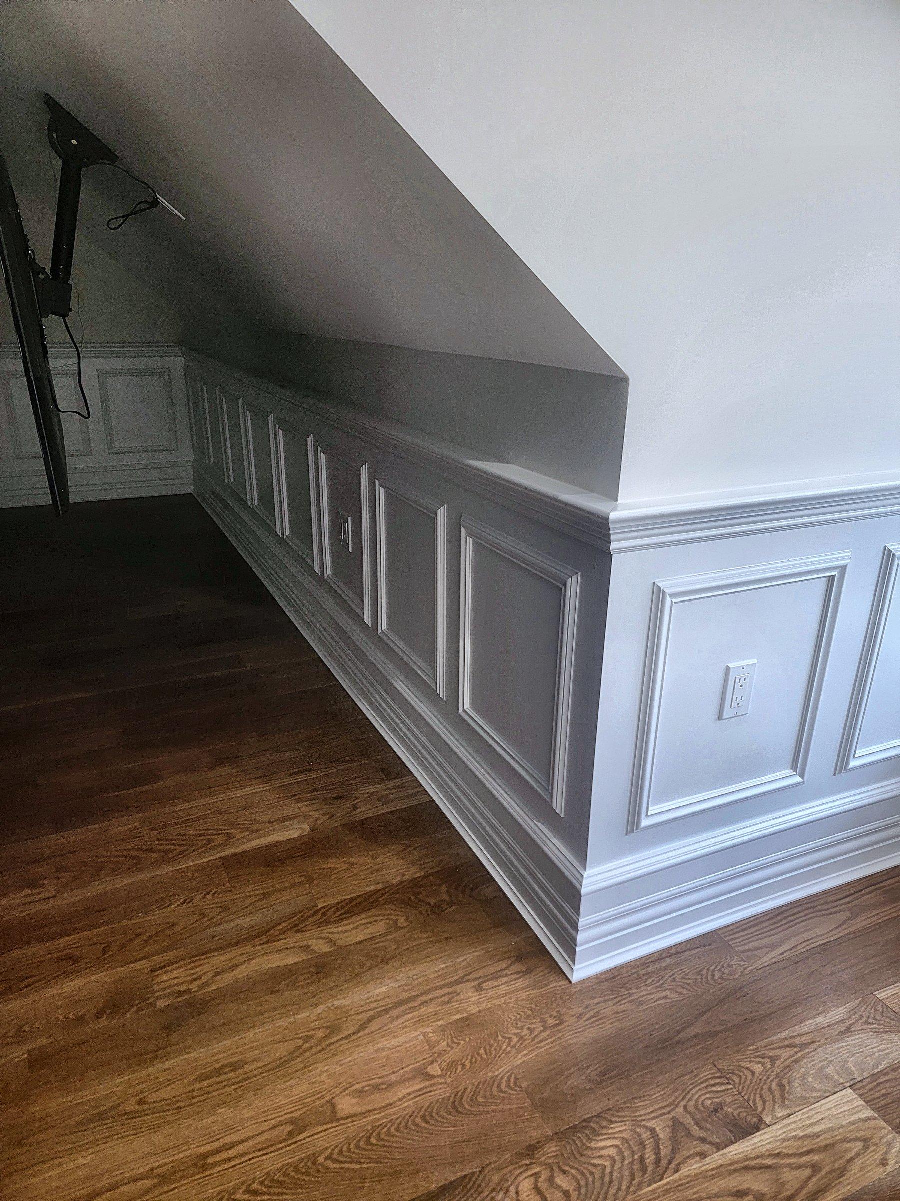 Raised-panel wainscot following the line of a sloped ceiling.